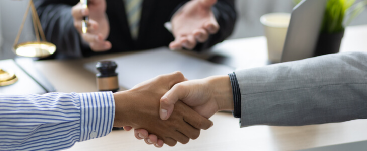 Two professionals shaking hands after a mediation appointment